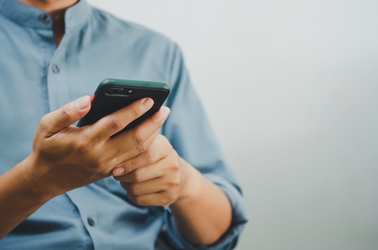 Close up of a man using mobile smart phone searching interne